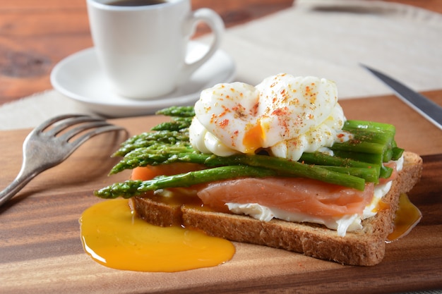 Poached egg with fried asparagus, cream cheese , salmon and spices on a toast. Healthy French breakfast concept