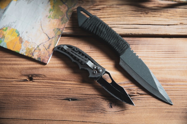 Pocket knife with map on wooden desk