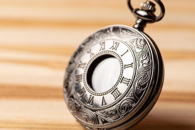 Photo pocket watch, beautiful details of a pocket watch positioned on a rustic wooden surface, selective focus.