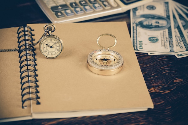 pocket watch over book note on wood table .