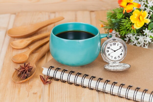 pocket watch and coffee cup on book.