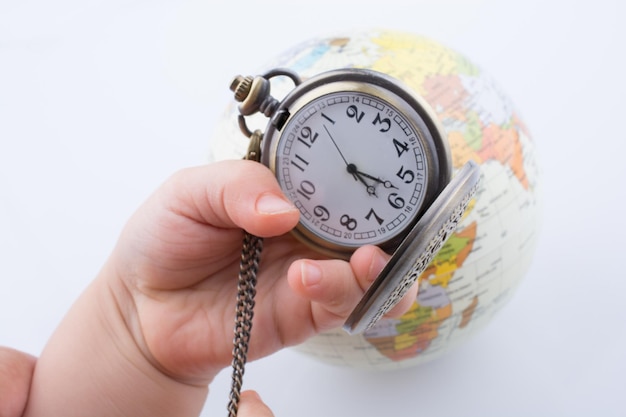 Pocket watch and a globe in hand