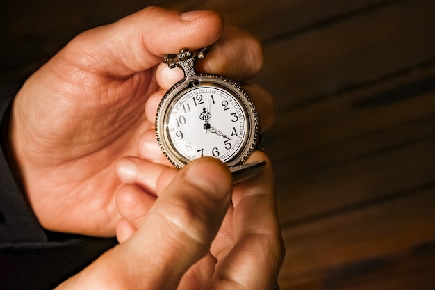 A pocket watch in the hands of a man