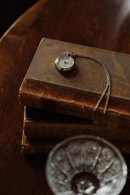 A pocket watch sits on a book with a pocket watch on it