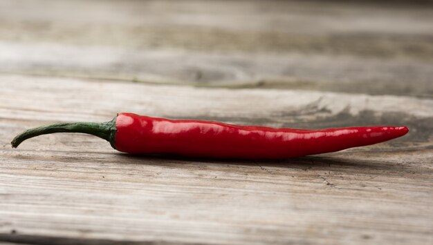 Pod of red chili pepper on a gray wooden board