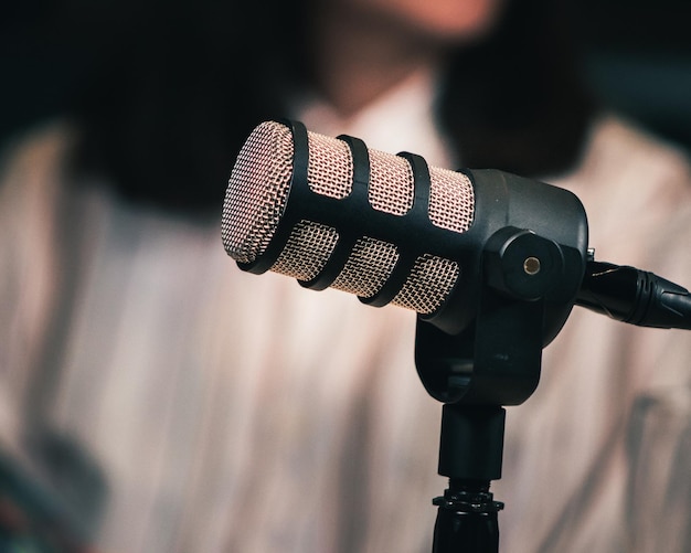 podcast microphone close up texture with blurry person in background