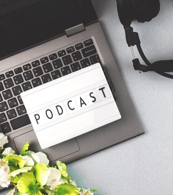 Podcast template concept with lightbox and text inscription laptop with headphones