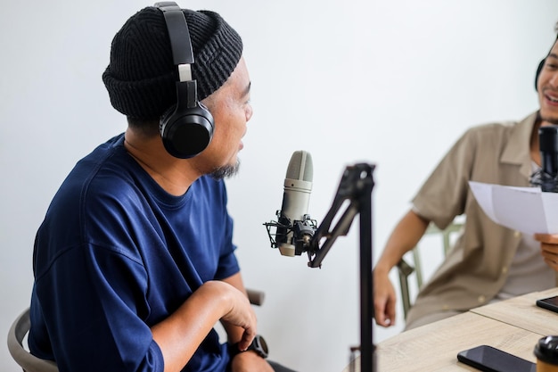 Podcastgast houdt creatieve discussies in een studio terwijl hij koptelefoon draagt