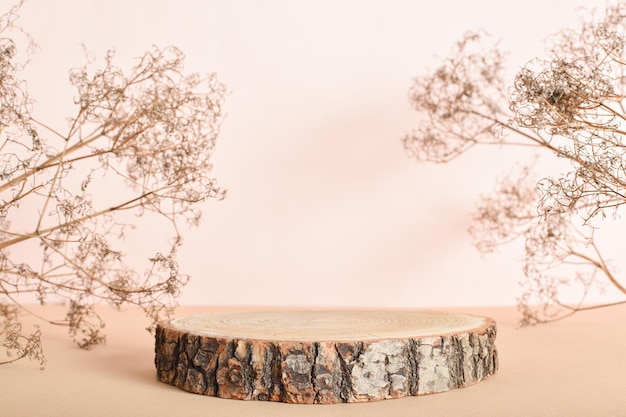 Podium made of natural wood with dried flowers on a beige background Minimalistic branding scene