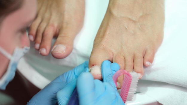 Podotherapeut maakt professionele pedicure van teennagels in schoonheidssalon close-up