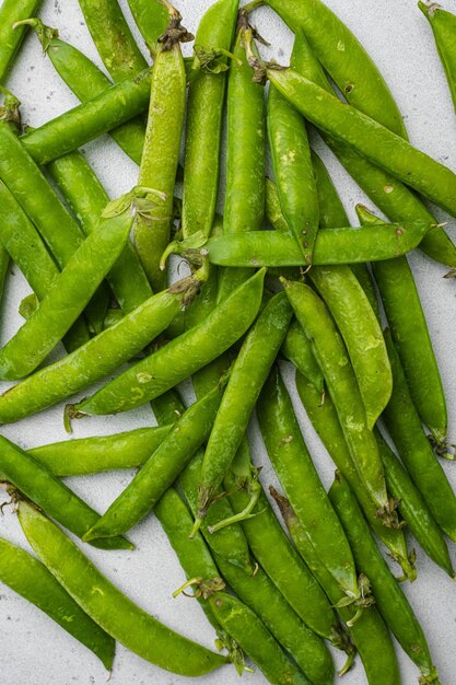 Pods of green peas top view flat lay