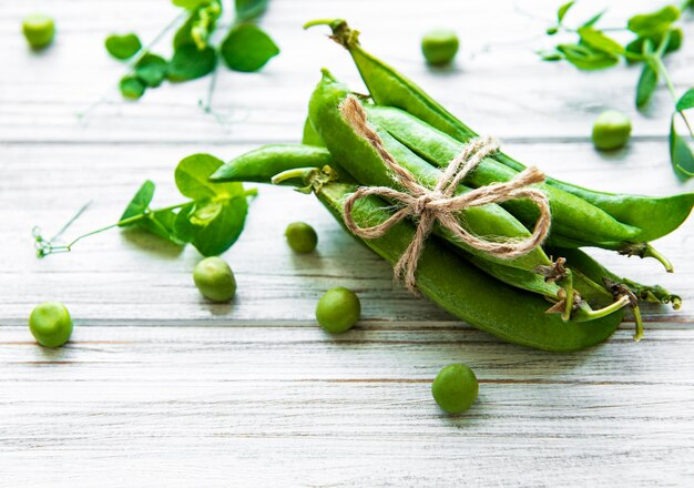 Pods of green peas with pea leaves