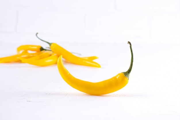 Фото Стручки желтого острого перца чили на белом фоне