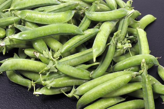 Pods of ripe green peas closeup