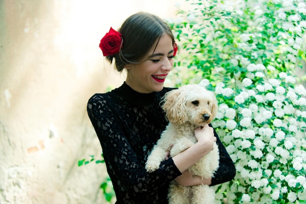 Poedelhond huisdier in de hand van gelukkig Spaans meisje