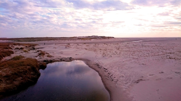Foto poel bij zandveld tegen de hemel bij zonsondergang