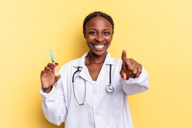 Indicando la telecamera con un sorriso soddisfatto, fiducioso, amichevole, scegliendo te. medico e concetto di siringa