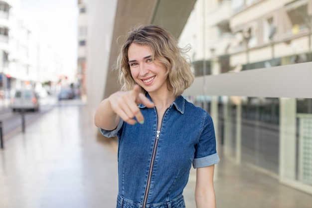 Pointing at camera with a satisfied confident friendly smile choosing you