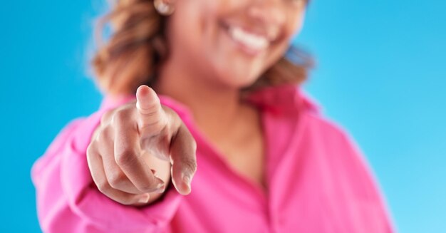 Foto indicare la scelta del dito e una donna su uno sfondo blu per il reclutamento, l'assunzione e la motivazione offerta sorriso e mano di una persona o ragazza con una decisione isolata sullo sfondo di uno studio per la promozione