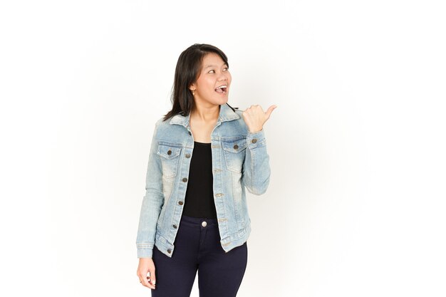 Указывая на правую сторону большим пальцем красивой азиатской женщины в джинсовой куртке и черной рубашке