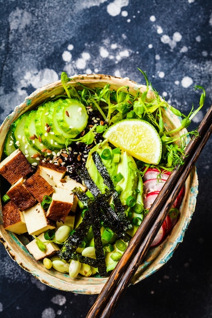 Poke bowl met avocado, zwarte rijst, gerookte tofu, groenten, spruitjes