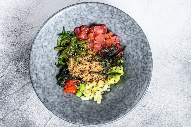 Poke bowl met rauwe tonijn en groenten. Hawaiiaans gerecht. Gezond eten concept. Grijze achtergrond. Bovenaanzicht