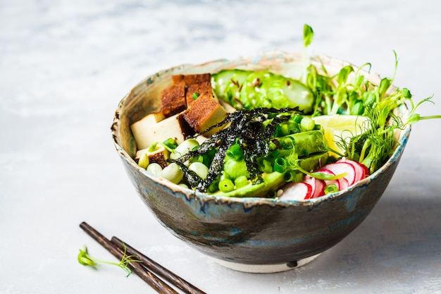 Poke bowl with avocado, black rice, smoked tofu, beans, vegetables, sprouts