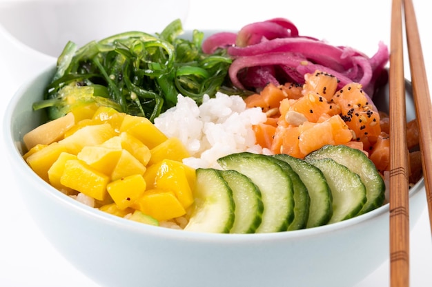 Poke bowl with rice salmoncucumbermangoonionwakame salad poppy seeds ands sunflowers seeds isolated on white background