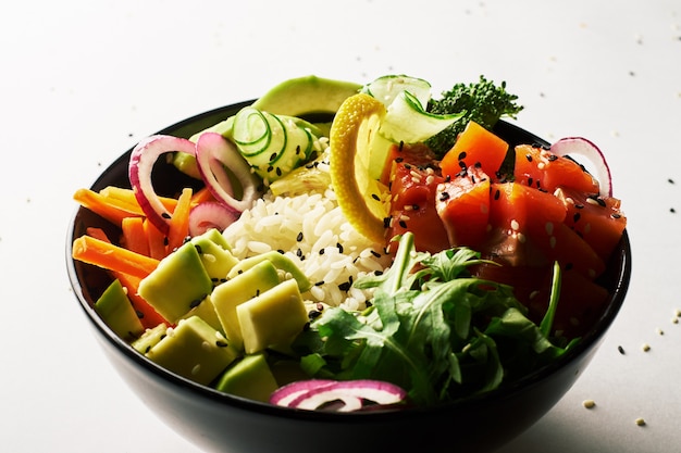 Poke bowl with salmon, avocado, isolated over white background. side view