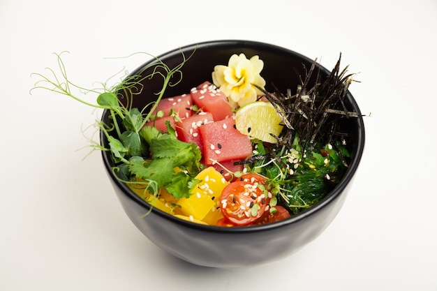 Poke salad with tuna in a bowl ingredients fresh tuna cherry tomatoes marinated seaweed