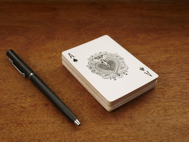 poker card game and pen on wood background