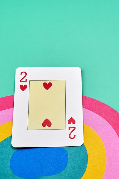 사진 초록색 배경의 사랑 개념과 함께 무지개 꼭대기에 있는 두 개의 하트의 포커 카드