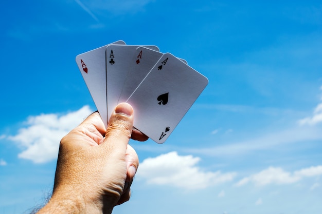 Foto schede di poker su sfondo blu cielo. assi in mano