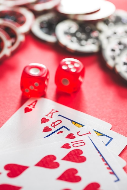 Foto carte da poker e dadi sul tavolo rosso