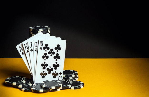 Poker cards with royal flush combination. Close-up of playing cards and chips in poker club. Free advertising space