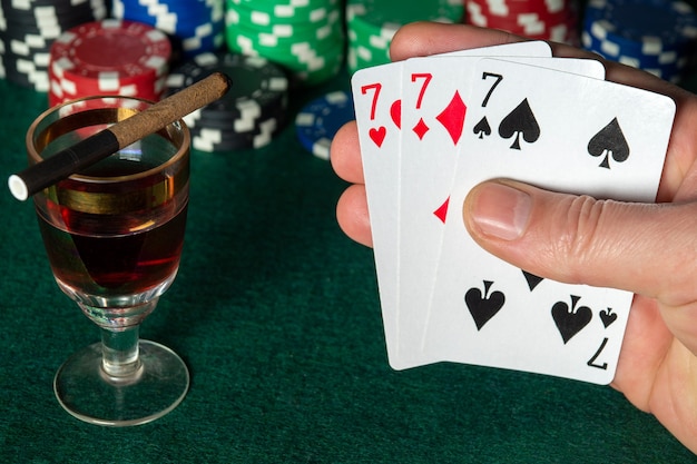 Карты для покера с тройкой или заданной комбинацией Крупный план руки игрока продолжает играть в карты