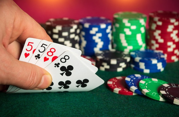 2ペアの組み合わせのポーカーカードギャンブラーの手のクローズアップはポーカークラブでトランプを取ります