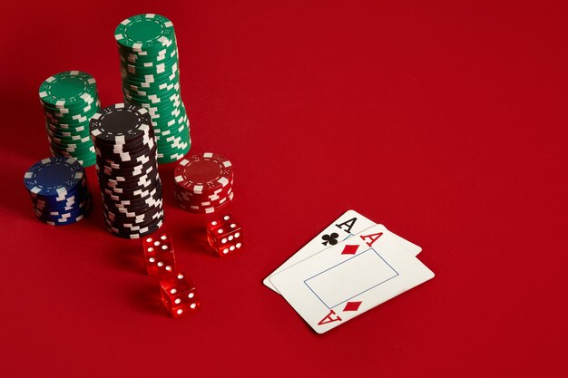 Poker chips and aces on red background. Group of different poker chips. Casino background. Copy space. Still life. One Pair