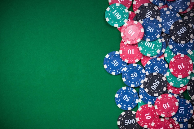 Poker chips on green casino table border background