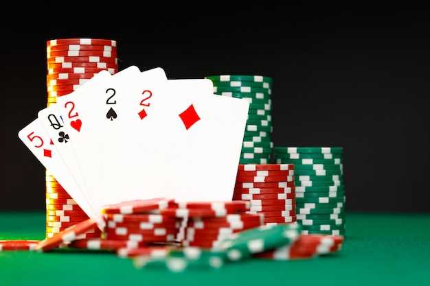 Фишки для покера и игральные карты на черном