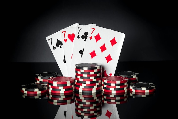 Poker game with four of a kind or quads combination chips and\
cards on black table