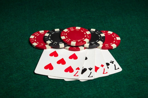 Poker game with four of a kind or quads combination Chips and cards on green table