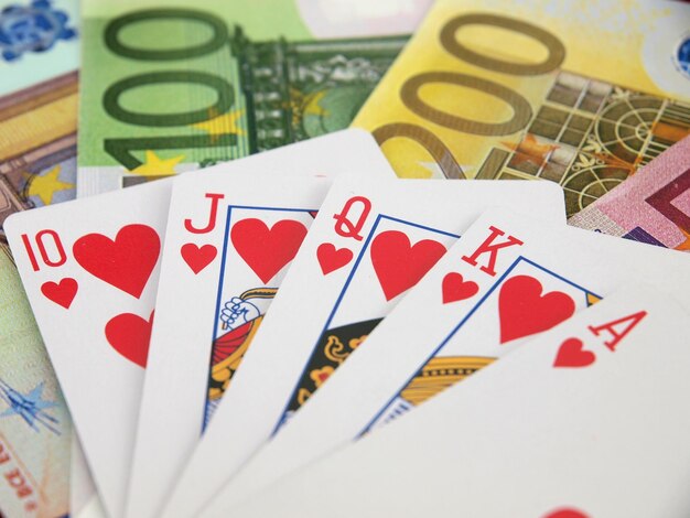 A poker hand with a card on it and a stack of money.