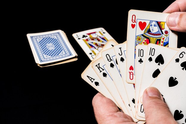 Poker kaartspel op een tafel. Hand met enkele kaarten die zijn spel tonen