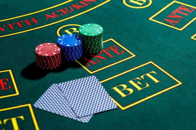 Poker play. Chips and cards on the green table