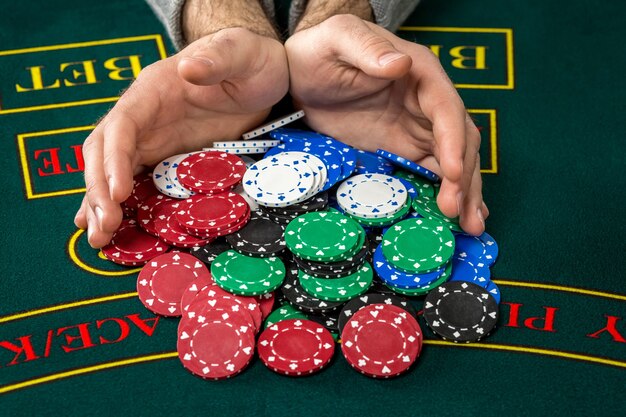 Poker play. Chips on the green table. chips in male hands