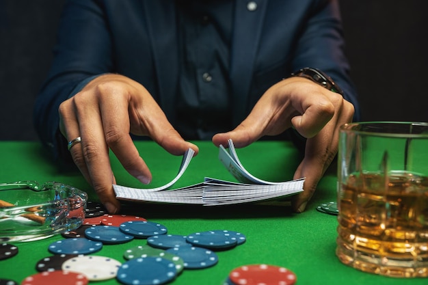 Il giocatore di poker mescola le carte da poker nel casinò