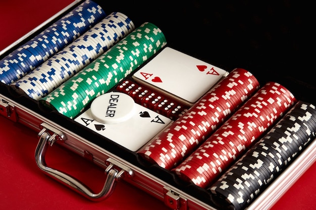 Photo poker set in metal suitcase risky entertainment of gambling top view on red background