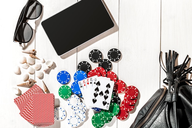 Poker. Set to playing poker with cards and chips on white wooden table, top view. Copy space