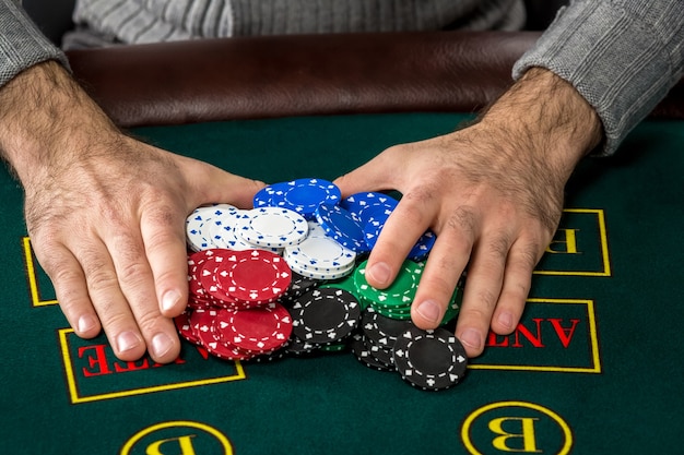 Poker spelen. Chips op de groene tafel. chips in mannelijke handen